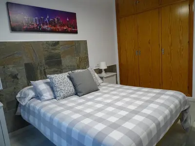 a bedroom with a bed with a checkered blanket at Apartamento Oropendola 9 in El Puerto de Santa María