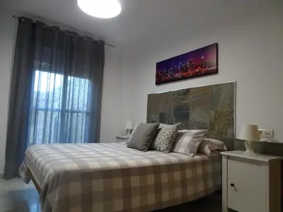 a bedroom with a bed and a tv on the wall at Apartamento Oropendola 9 in El Puerto de Santa María