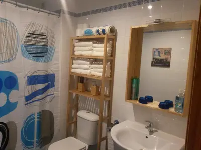 a bathroom with a sink and a toilet and a mirror at Apartamento Oropendola 9 in El Puerto de Santa María