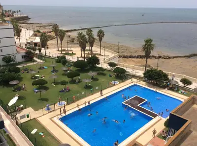 an overhead view of a swimming pool next to a beach at Villablanca Apartamento in Chipiona