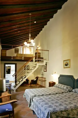 a bedroom with two beds and a staircase at Posada de Palacio in Sanlúcar de Barrameda