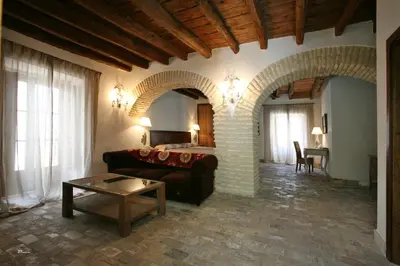 a living room with a couch and a bed at Posada de Palacio in Sanlúcar de Barrameda