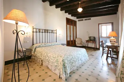 a bedroom with a bed with a lamp and a desk at Posada de Palacio in Sanlúcar de Barrameda