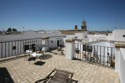 a patio with a table and chairs on a balcony at Posada de Palacio in Sanlúcar de Barrameda
