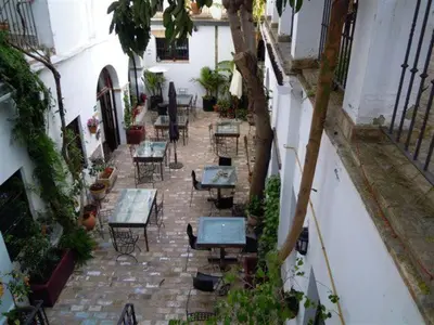 an outdoor patio with tables and chairs in a building at Posada de Palacio in Sanlúcar de Barrameda