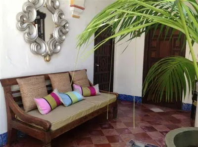 a couch with pillows in a room with a mirror at Posada de Palacio in Sanlúcar de Barrameda