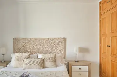 a bedroom with a bed with white sheets and pillows at Studio Novena Little Apartments in Cádiz