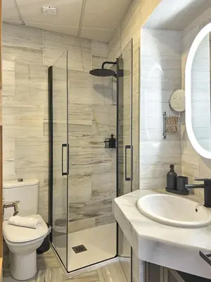 a bathroom with a shower and a toilet and a sink at Studio Novena Little Apartments in Cádiz