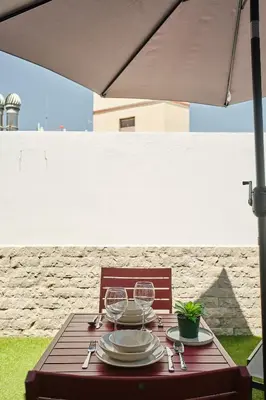 a wooden table with plates and wine glasses on it at Studio Novena Little Apartments in Cádiz