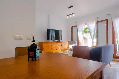 a dining room with a table and a television at Maracaibo in Chiclana de la Frontera