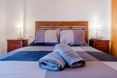a bedroom with a bed with two towels on it at Maracaibo in Chiclana de la Frontera