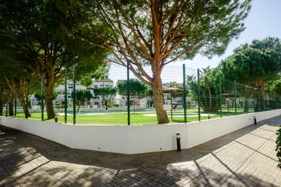 a white wall with trees in a park at Maracaibo in Chiclana de la Frontera