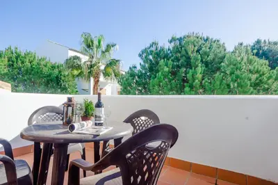 a table and chairs on a balcony with a window at Maracaibo in Chiclana de la Frontera
