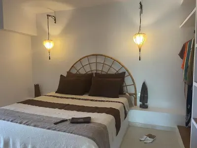 a bedroom with a large bed with two lights at Kasbah Andaluz guest house in Chiclana de la Frontera