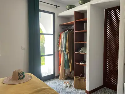 a room with a bed and a closet with a hat at Kasbah Andaluz guest house in Chiclana de la Frontera