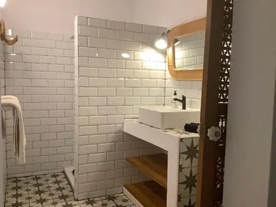 a white bathroom with a sink and a mirror at Kasbah Andaluz guest house in Chiclana de la Frontera