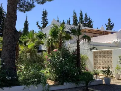 a house with palm trees in front of it at Kasbah Andaluz guest house in Chiclana de la Frontera
