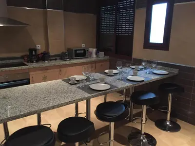 a kitchen with a table with chairs and wine glasses at Cadiz Deluxe Apartment in Cádiz