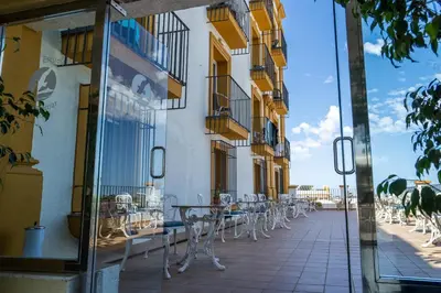 a row of tables and chairs outside a building at Hotel Balneario de Chiclana in Chiclana de la Frontera