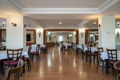 a dining room with white tables and chairs at Hotel Balneario de Chiclana in Chiclana de la Frontera