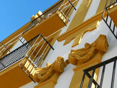 a yellow and white building with fire escapes at Hotel Balneario de Chiclana in Chiclana de la Frontera