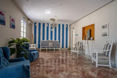 a living room with blue and white striped walls at Hotel Balneario de Chiclana in Chiclana de la Frontera