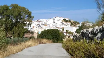 a road in front of a white village on a hill at Elegant Villa in Algar with Private Pool in Algar