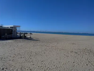 a sandy beach with umbrellas and the ocean at Casa Inocencio in El Puerto de Santa María