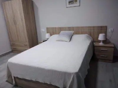 a bedroom with a large white bed with two night stands at Casa Inocencio in El Puerto de Santa María