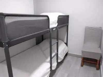 a black bunk bed in a room with a chair at Casa Inocencio in El Puerto de Santa María