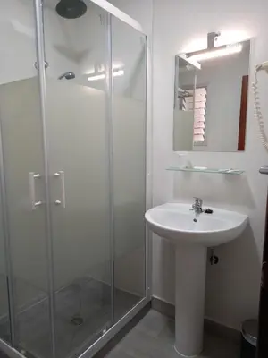 a bathroom with a glass shower and a sink at Casa Inocencio in El Puerto de Santa María