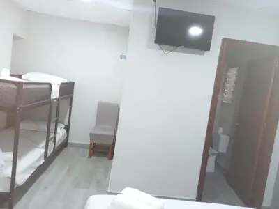 a room with bunk beds and a mirror and a television at Casa Inocencio in El Puerto de Santa María