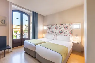 a bedroom with a large bed and a window at Itaca Jerez by Soho Boutique in Jerez de la Frontera
