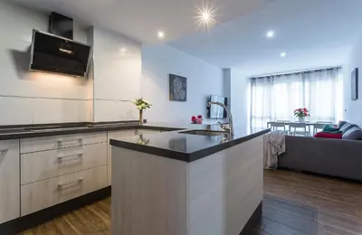 a kitchen with a counter top and a living room at Playa Victoria Paseo Marítimo 3 Rooms in Cádiz