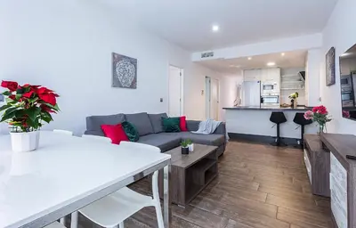 a living room and kitchen with a couch and a table at Playa Victoria Paseo Marítimo 3 Rooms in Cádiz