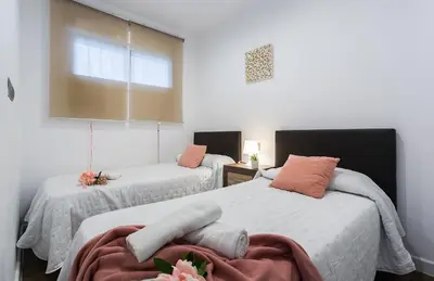 a bedroom with two beds and a window at Playa Victoria Paseo Marítimo 3 Rooms in Cádiz
