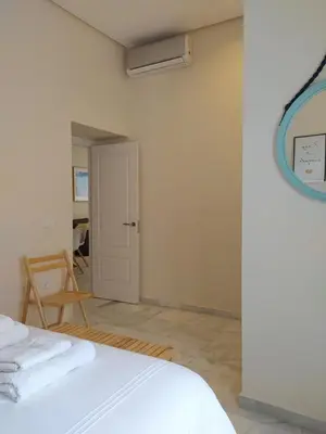 a white room with a bed and a mirror at Sherryflat Azahar in Jerez de la Frontera
