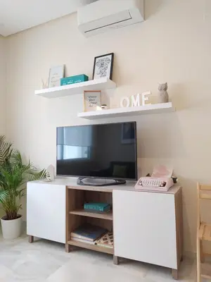 a living room with a television on a white cabinet at Sherryflat Azahar in Jerez de la Frontera