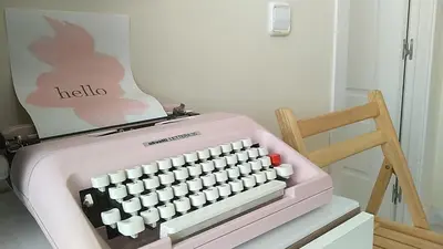 a pink computer keyboard sitting next to a wooden chair at Sherryflat Azahar in Jerez de la Frontera