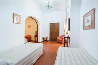 a hotel room with two beds and a chair at Hotel Marqués de Torresoto by Vivere Stays in Arcos de la Frontera