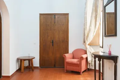 a room with a chair and a wooden door at Hotel Marqués de Torresoto by Vivere Stays in Arcos de la Frontera