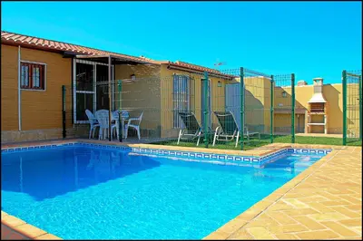 a swimming pool in front of a house at Bungalow Curro Pareja 131 in Conil de la Frontera