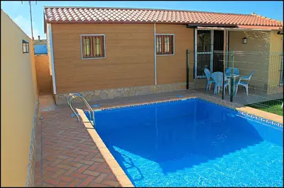 a swimming pool in front of a house at Bungalow Curro Pareja 131 in Conil de la Frontera