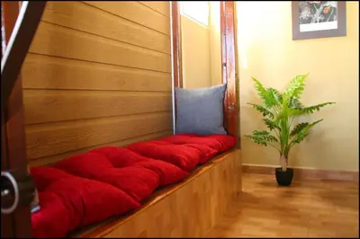 a red couch in a room with a potted plant at Bungalow Curro Pareja 131 in Conil de la Frontera