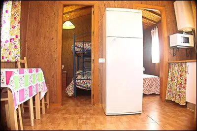 a refrigerator in a room with two bunk beds at Bungalow Curro Pareja 131 in Conil de la Frontera
