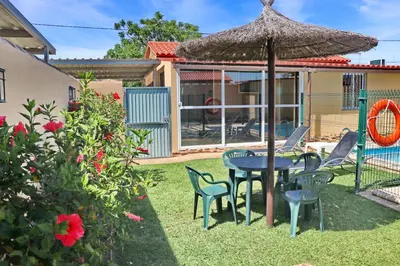 a patio with a table and chairs and an umbrella at Bungalow Curro Pareja 97 in Conil de la Frontera