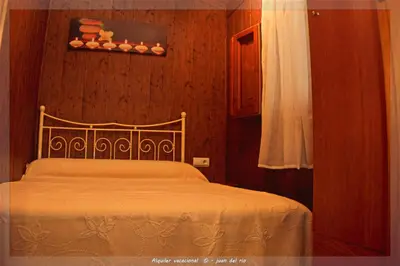 a bedroom with a bed and a wooden wall at Bungalow Curro Pareja 97 in Conil de la Frontera