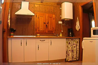 a kitchen with white cabinets and a sink and a microwave at Bungalow Curro Pareja 97 in Conil de la Frontera