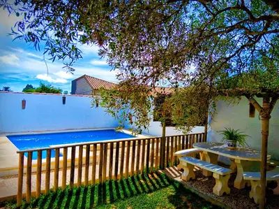 a wooden fence with a bench next to a pool at Chalet Mari Carmen in Chiclana de la Frontera