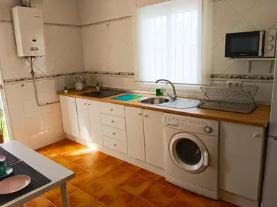 a kitchen with a sink and a washing machine at Chalet Mari Carmen in Chiclana de la Frontera